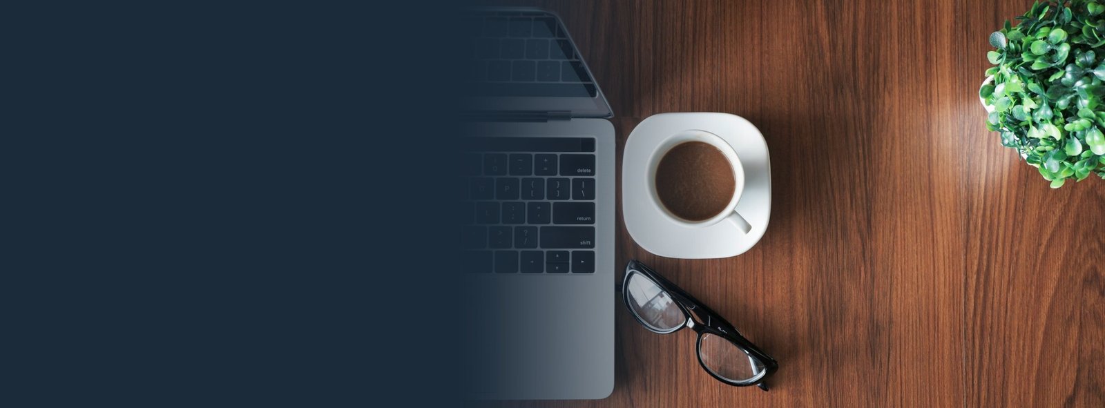 Laptop y taza de café sobre un escritorio de madera