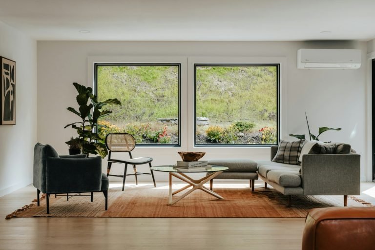 Sala amplia con sofás, plantas y grandes ventanales